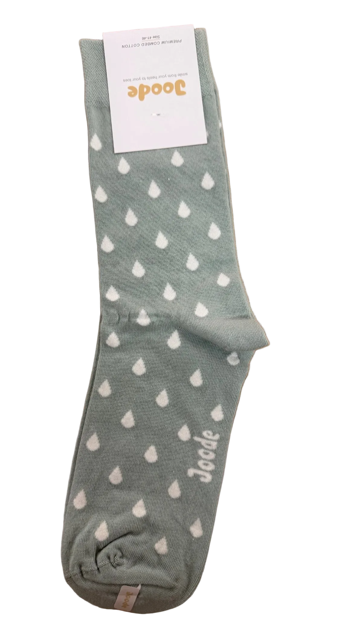 A single light sage green sock with a white raindrop pattern, featuring a white paper tag with the brand name 'Joode' at the top and 'Joode' printed near the toe, laid flat on a wooden floor.