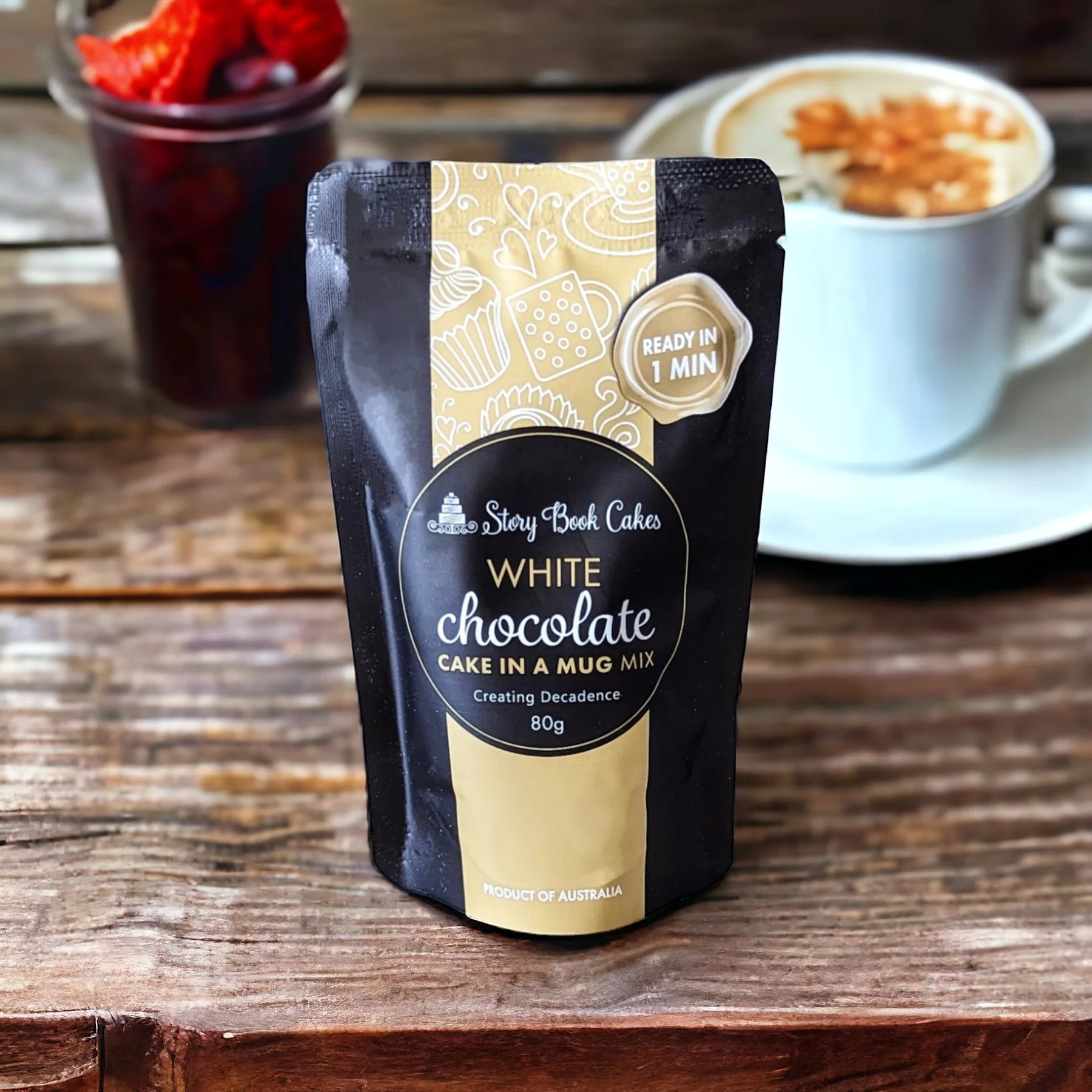White chocolate product packaging on a wooden surface with a cup of coffee and fruit in the background.