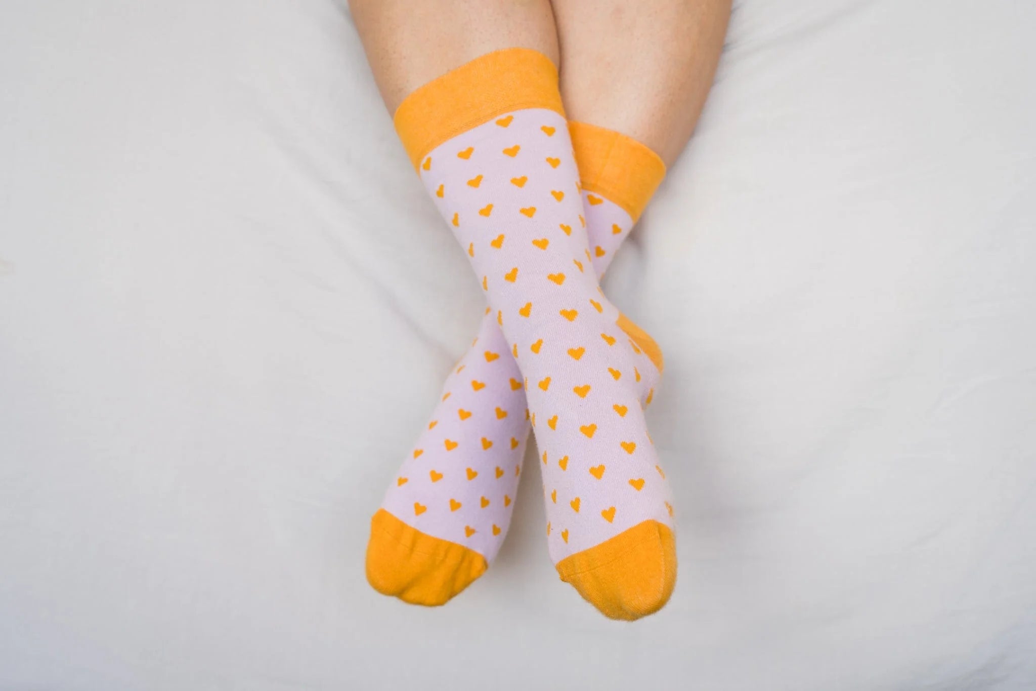 White socks with orange hearts and cuffs on a white background